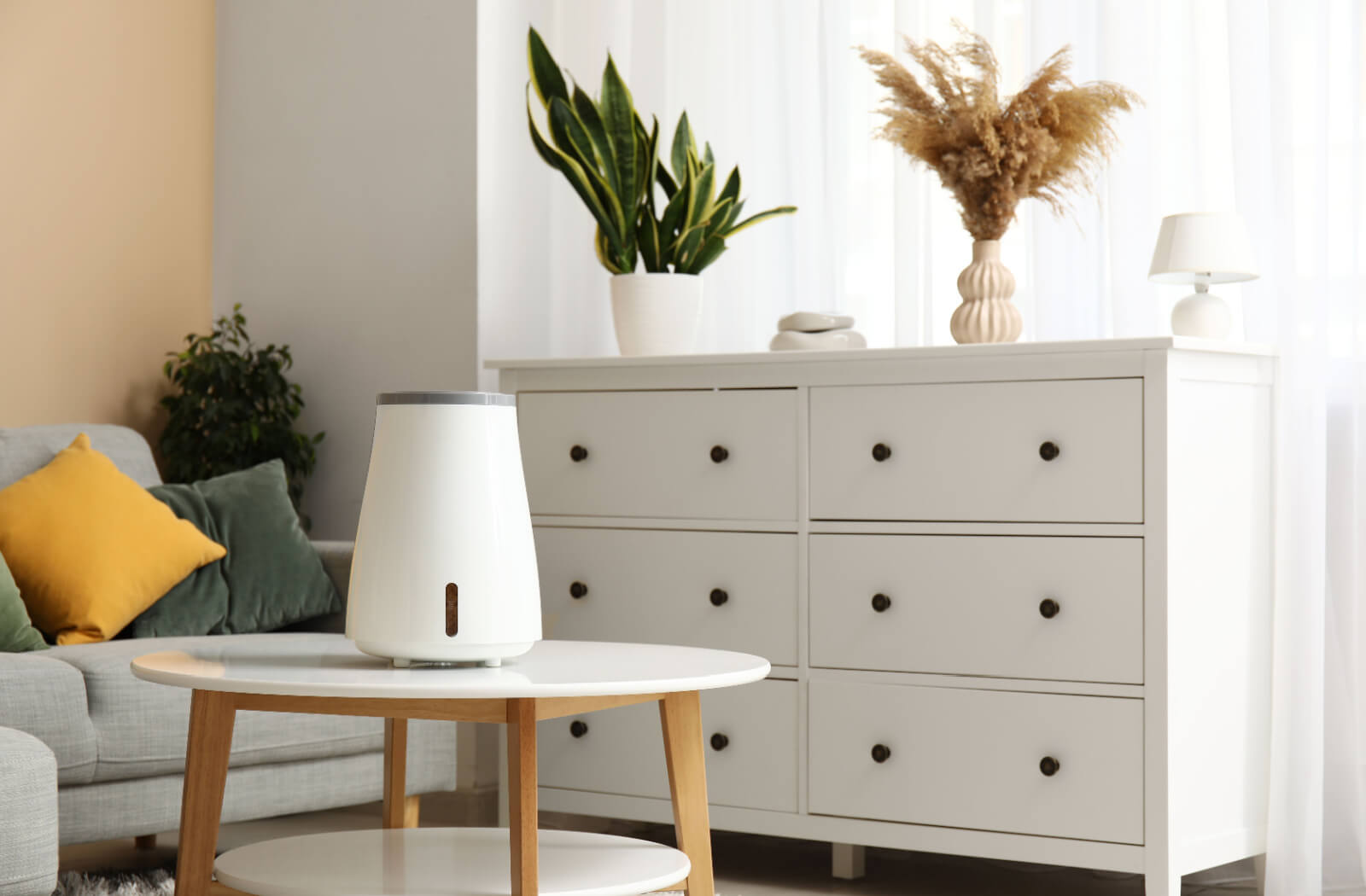 A humidifier on a small table in the middle of a well-decorated living room to reduce dry eye irritation.
