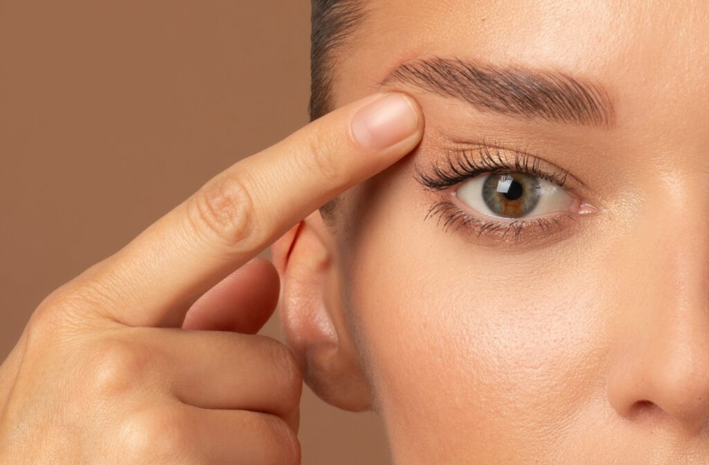 Close up of adult lifting their eye area with their finger to give a youthful and open-eyed look