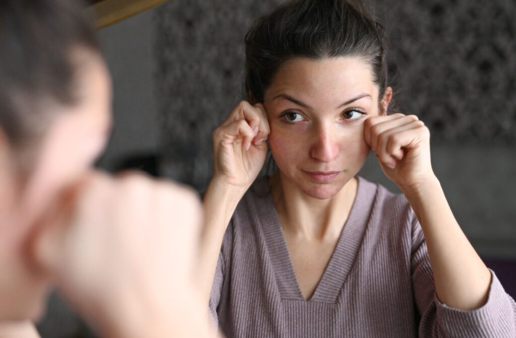 Adult looking in the mirror while gently cleansing their eye area